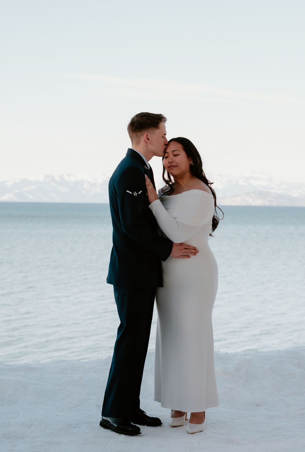 A romantic winter wedding photo series shows a couple embracing against a snowy mountain backdrop.