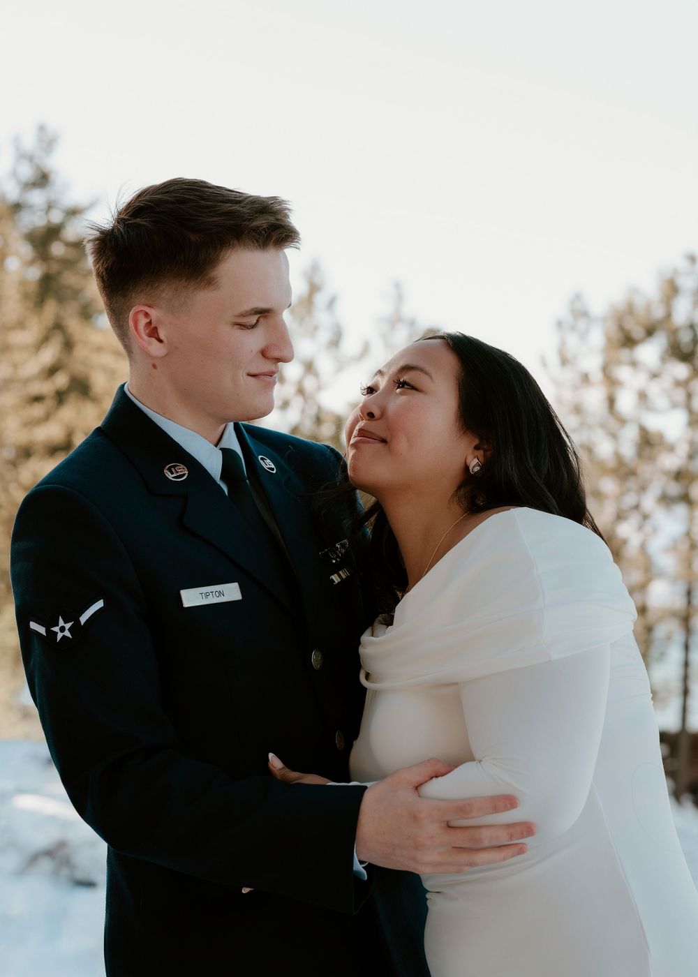 A romantic winter wedding photo series showing a couple embracing in a snowy outdoor setting.