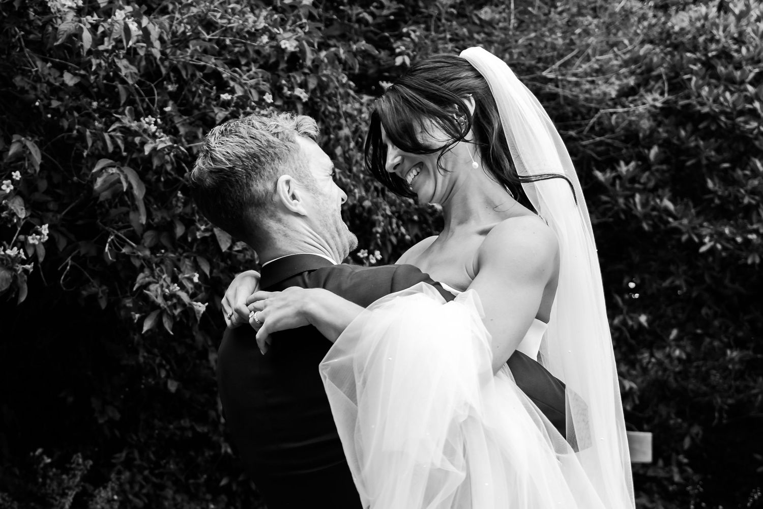 A black and white photo series showing tender moments between a couple during an intimate wedding ceremony.