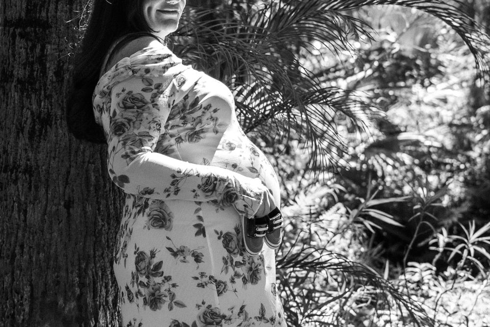 A black and white photo montage shows someone in a floral dress walking through a garden with dappled sunlight.