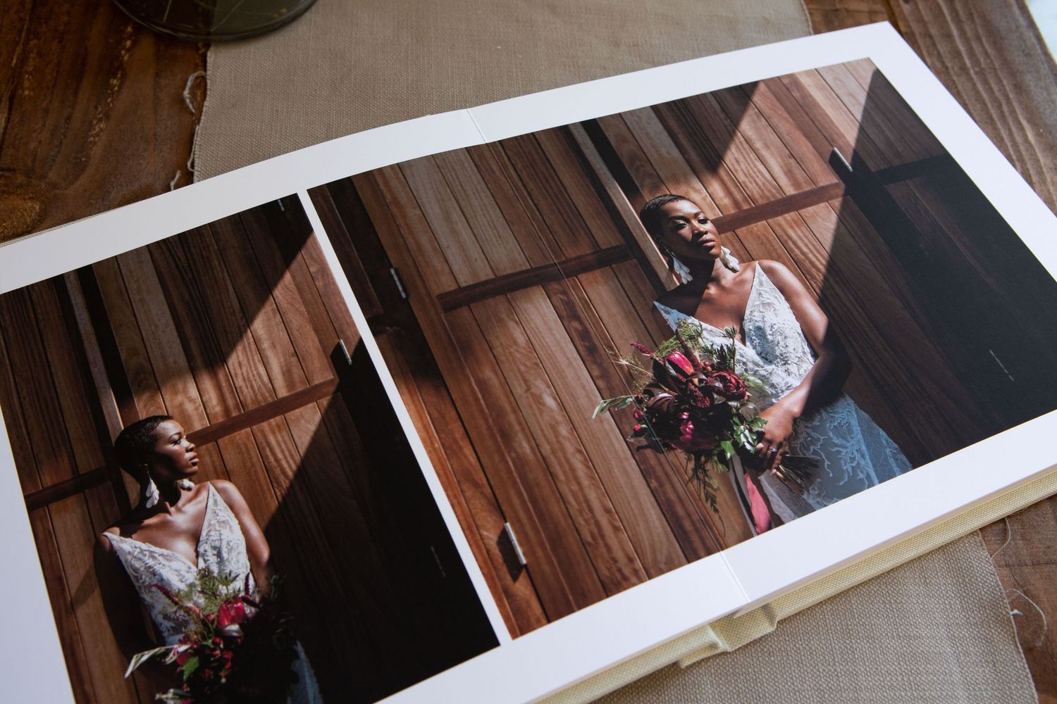 A couple in elegant wedding attire dances together in a warmly lit wooden venue.