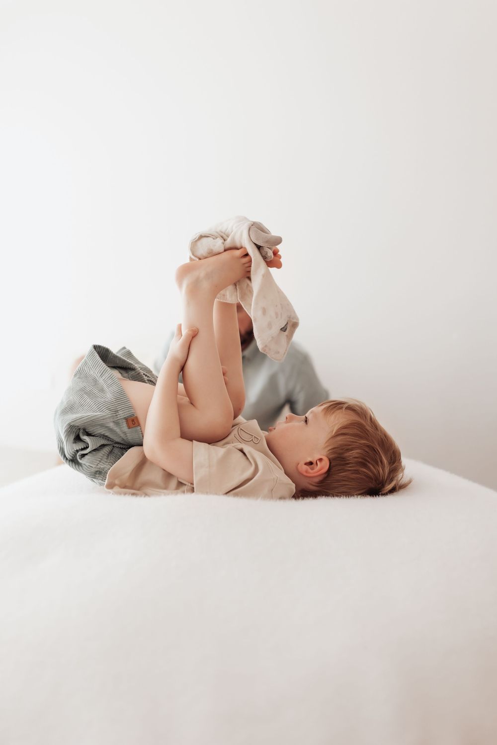 A sequence of tender parent-child interactions photographed on a white surface.