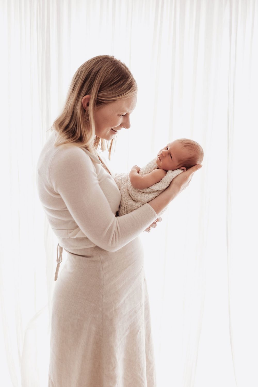 Series of tender moments between parent and newborn baby in light-filled studio setting.