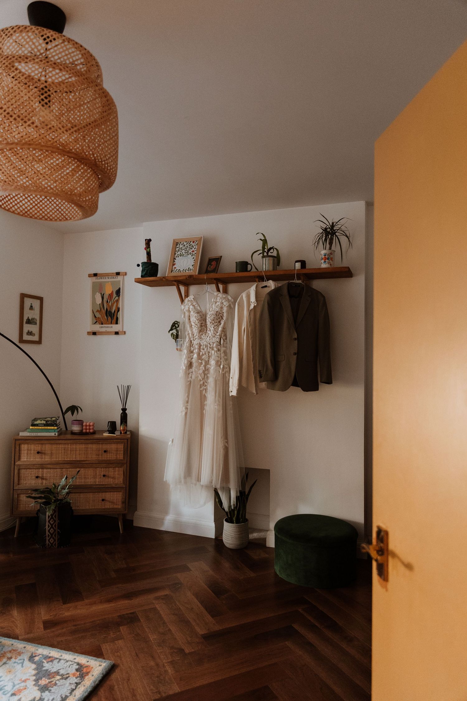 Interior room with wooden flooring, white walls, rustic wooden shelves, and hanging pendant light fixture creating a warm ambiance.