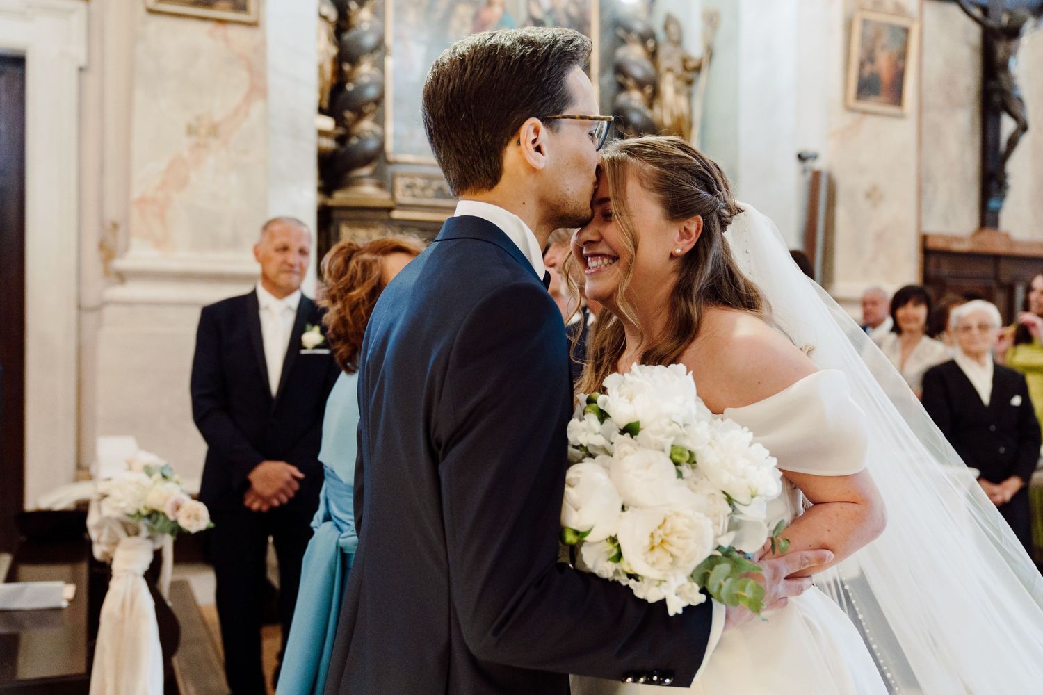 Bride and groom share a joyful moment at the altar during their church wedding ceremony.