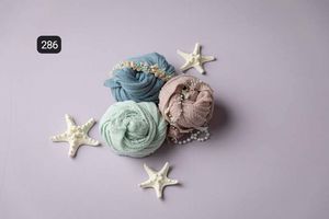Seafoam green fabric wraps styled with starfish decorations on purple background.