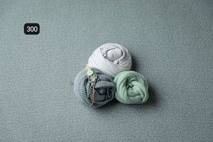 Gentle fabric wraps positioned on a light gray textured surface.