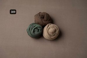 Sage green and neutral fabric wraps styled on a taupe background.
