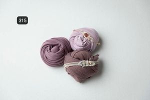 Soft mauve fabric wraps arranged in circular bundles against a light gray background.