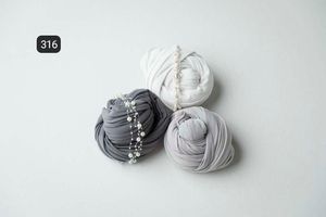 Light gray textile wraps displayed in a minimalist arrangement on white surface.
