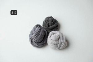 Two gray fabric bundles arranged artistically on white background.