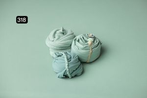 Mint green fabric wraps positioned elegantly on matching background.