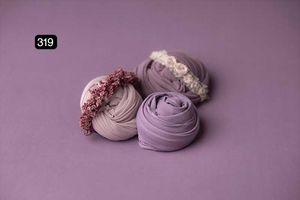 Purple fabric wraps with delicate details arranged on lavender background.