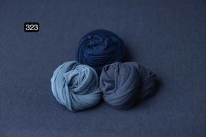 Navy blue fabric wraps arranged artistically on dark background.