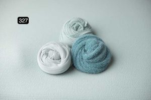 White and turquoise fabric wraps positioned on light gray surface.