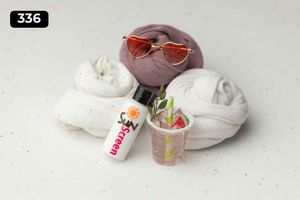 Fabric wraps with sunglasses and small decorative accessories on white surface.