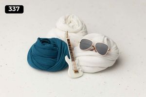 Wrapped fabric bundles with sunglasses and a small decorative item on light background.