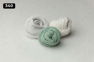 Three fabric wraps in mint green and white colors on light gray surface.
