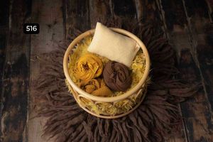Round wooden bowls with golden yellow fabrics on dark textured background.