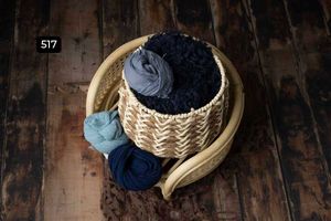 Navy blue and light blue textiles displayed in woven baskets on dark wooden floor.