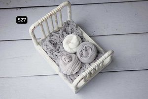Vintage white decorative baskets arranged on light wooden planks.
