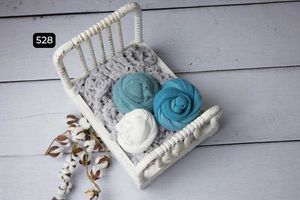 White and turquoise decorative elements displayed in vintage baskets on gray wooden surface.