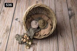 Woven baskets with neutral colored yarns arranged on rustic wooden planking.