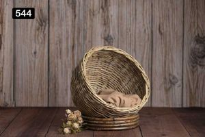 Empty woven basket with rustic wooden background and small dried flowers.