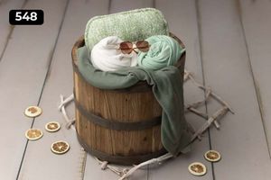 Rustic wooden barrel with mint and white fabrics and decorative wooden stars.