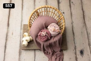 Rattan chair prop with pink fabric wraps and small decorative elements.