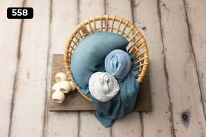 Rattan chair with blue and white fabric wraps and decorative elements on light background.