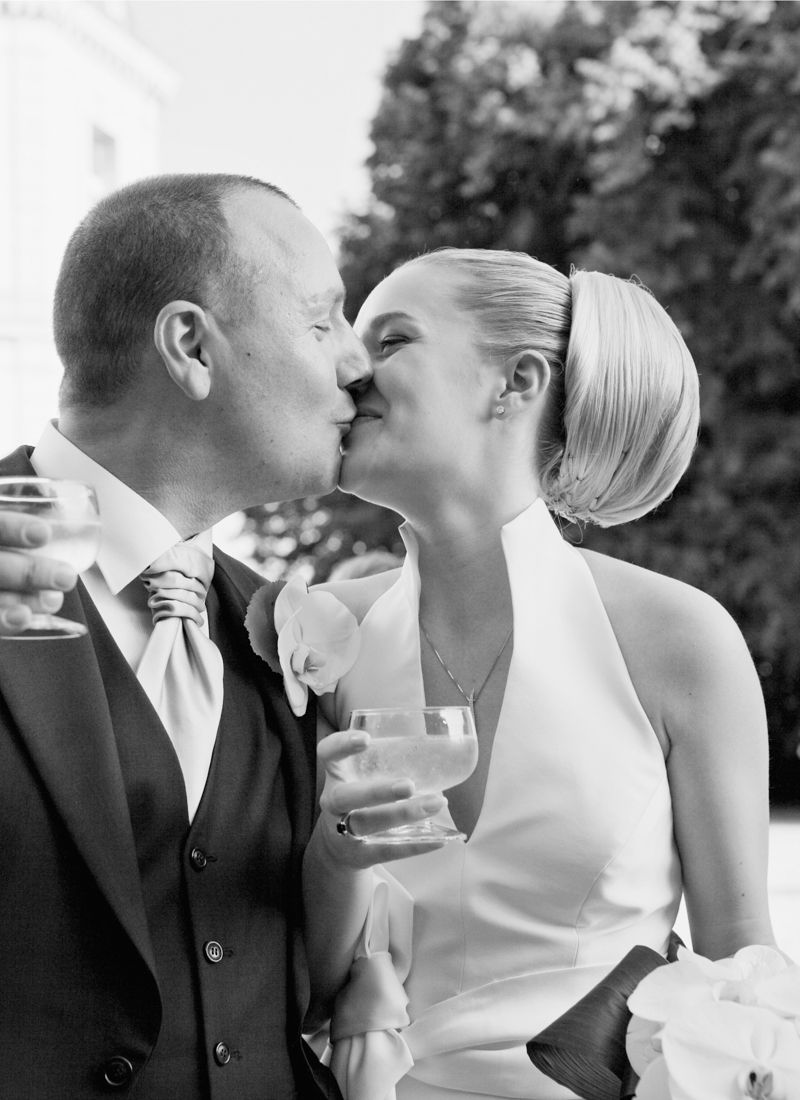 Bride and groom sharing a kiss during cocktails at Château de Santeny wedding near Paris