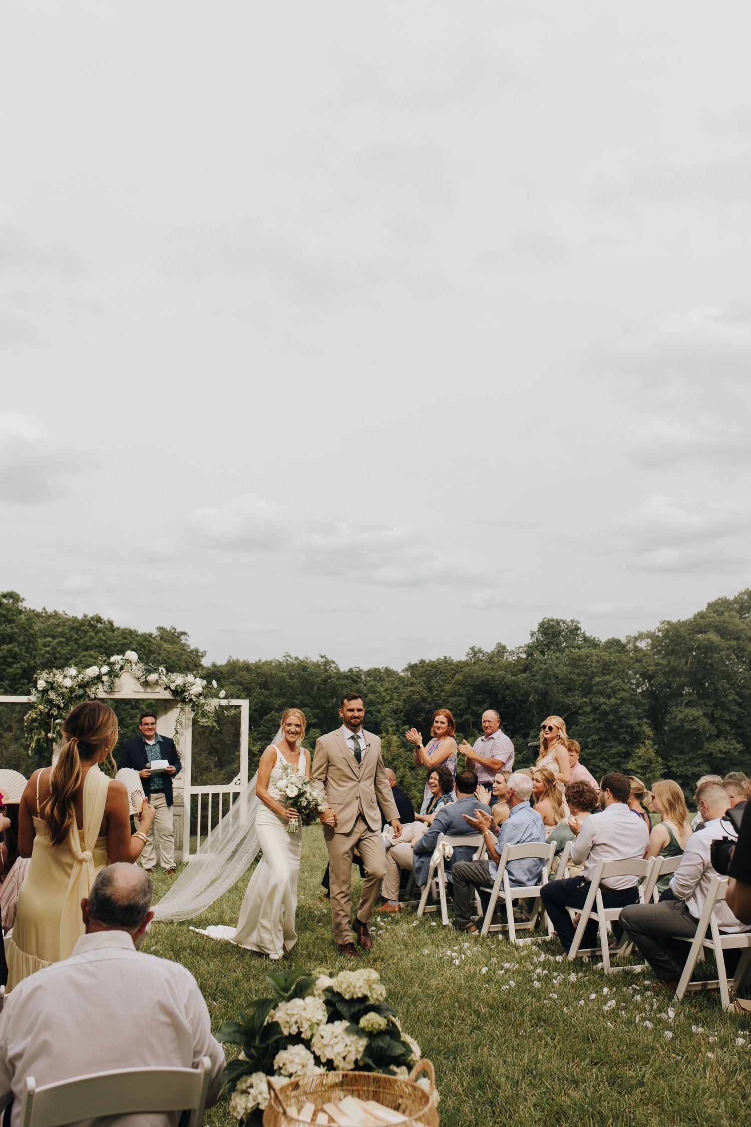 Couple walking back down the aisle for the first time as husband and wife in elegant backyard Athens, Ohio wedding.