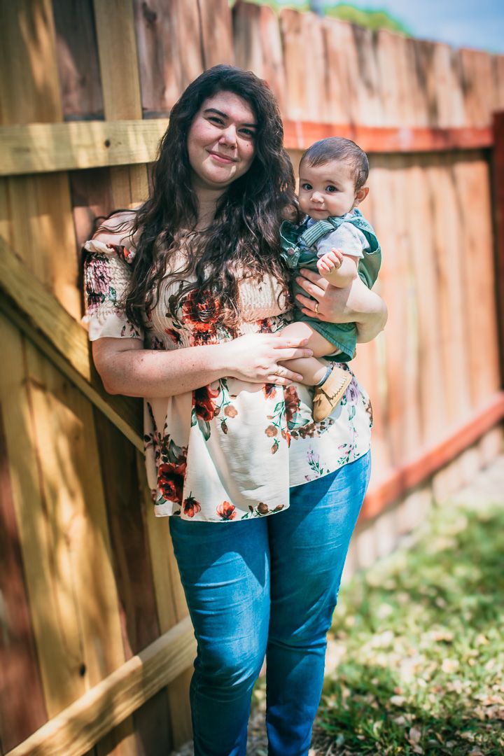 Mother holding her baby in the sun light.