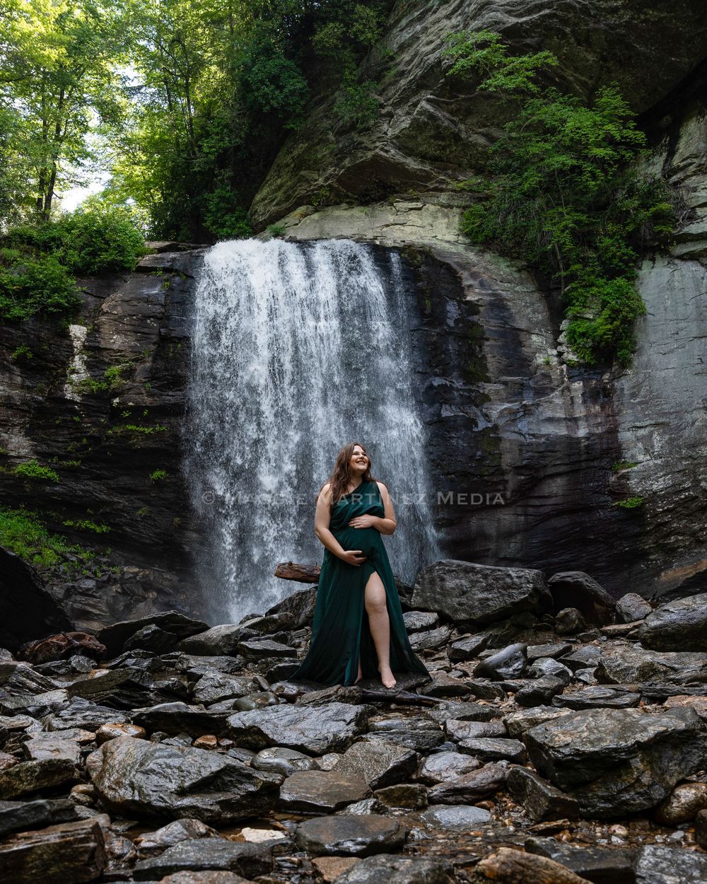 A stunning waterfall cascades down rocky cliffs in a lush forest setting.