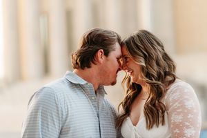 A romantic couple in wedding attire share intimate moments during a photo session on a sun-lit patio.