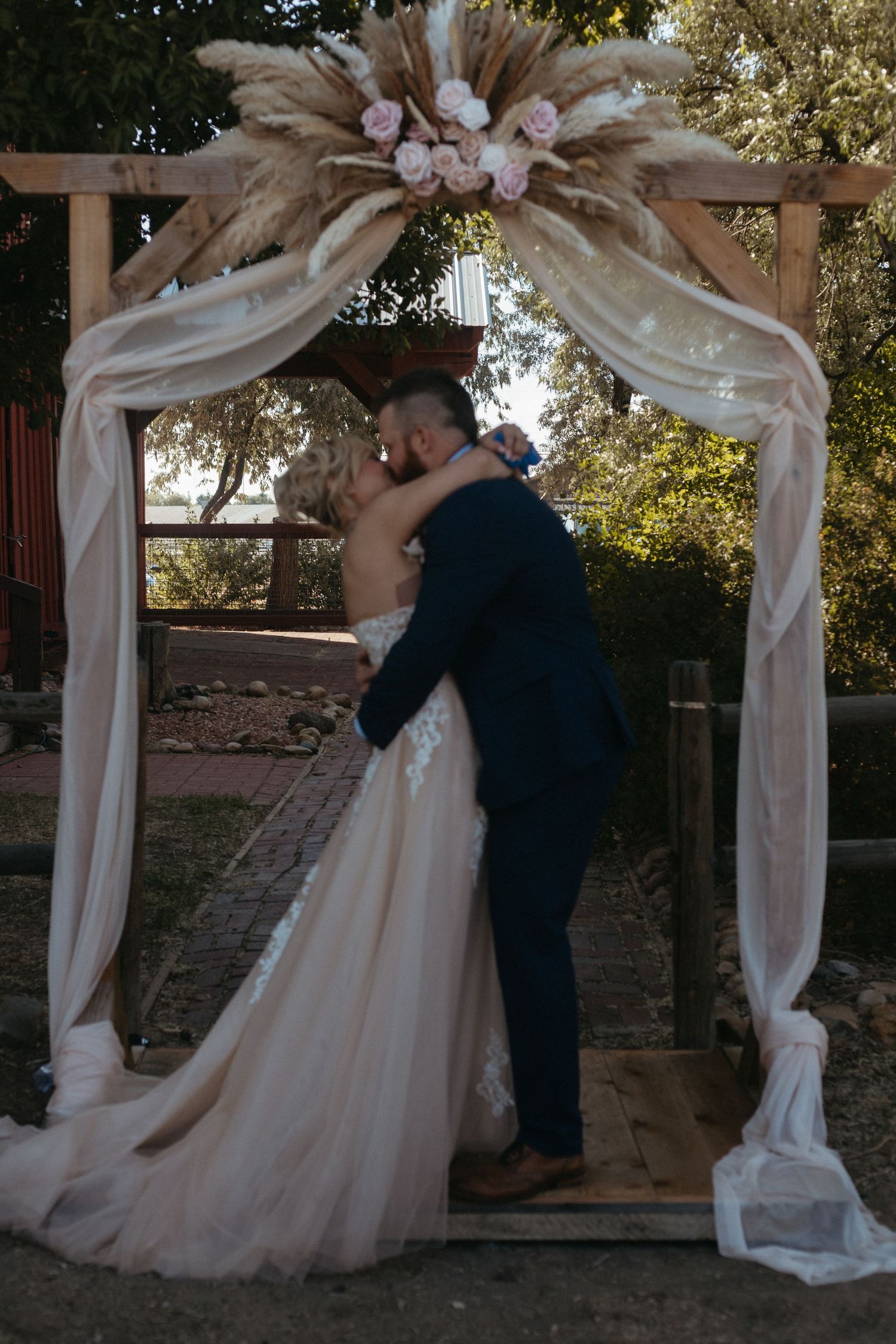 A romantic wedding dance captured under an elegant draped arch with floral decorations.