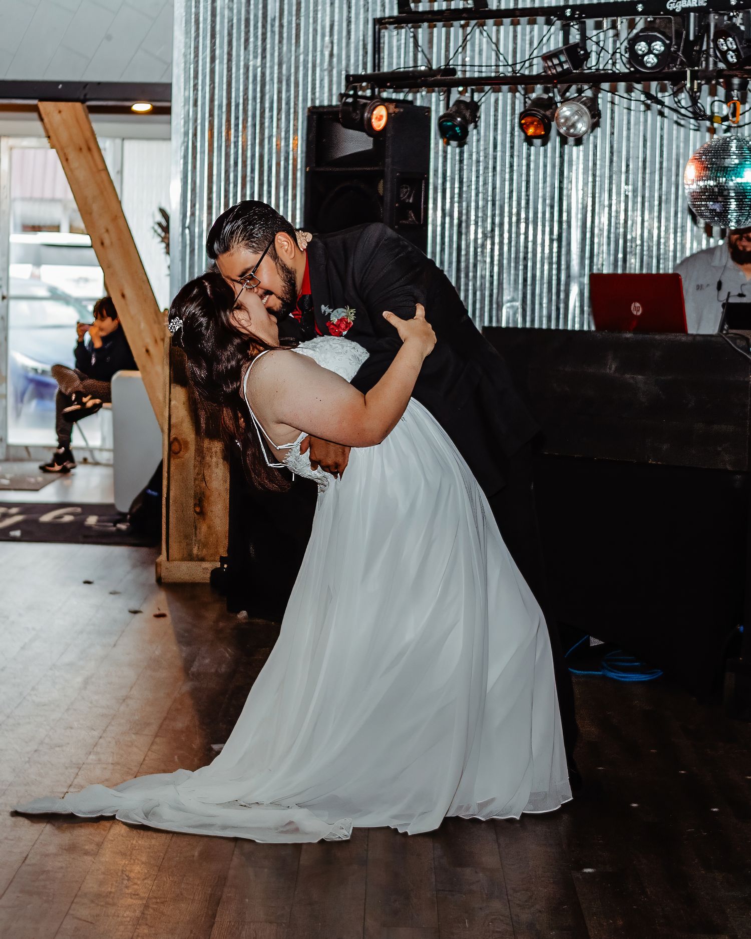 A romantic dip during a wedding dance in an industrial-style venue.