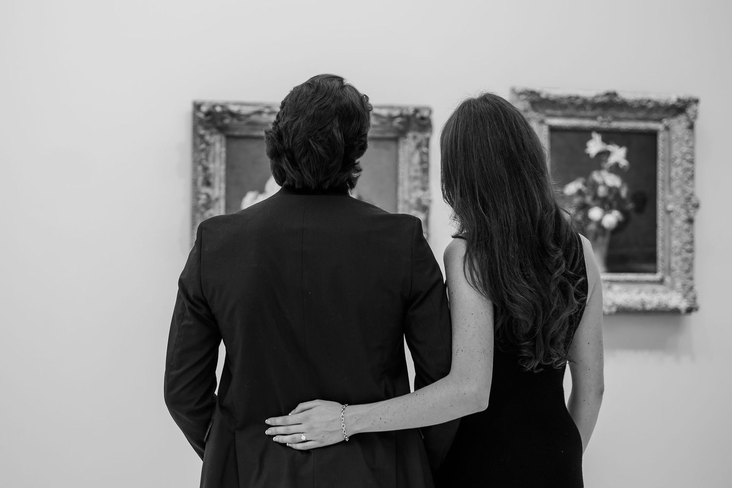 Couple viewing framed artwork in a museum gallery.