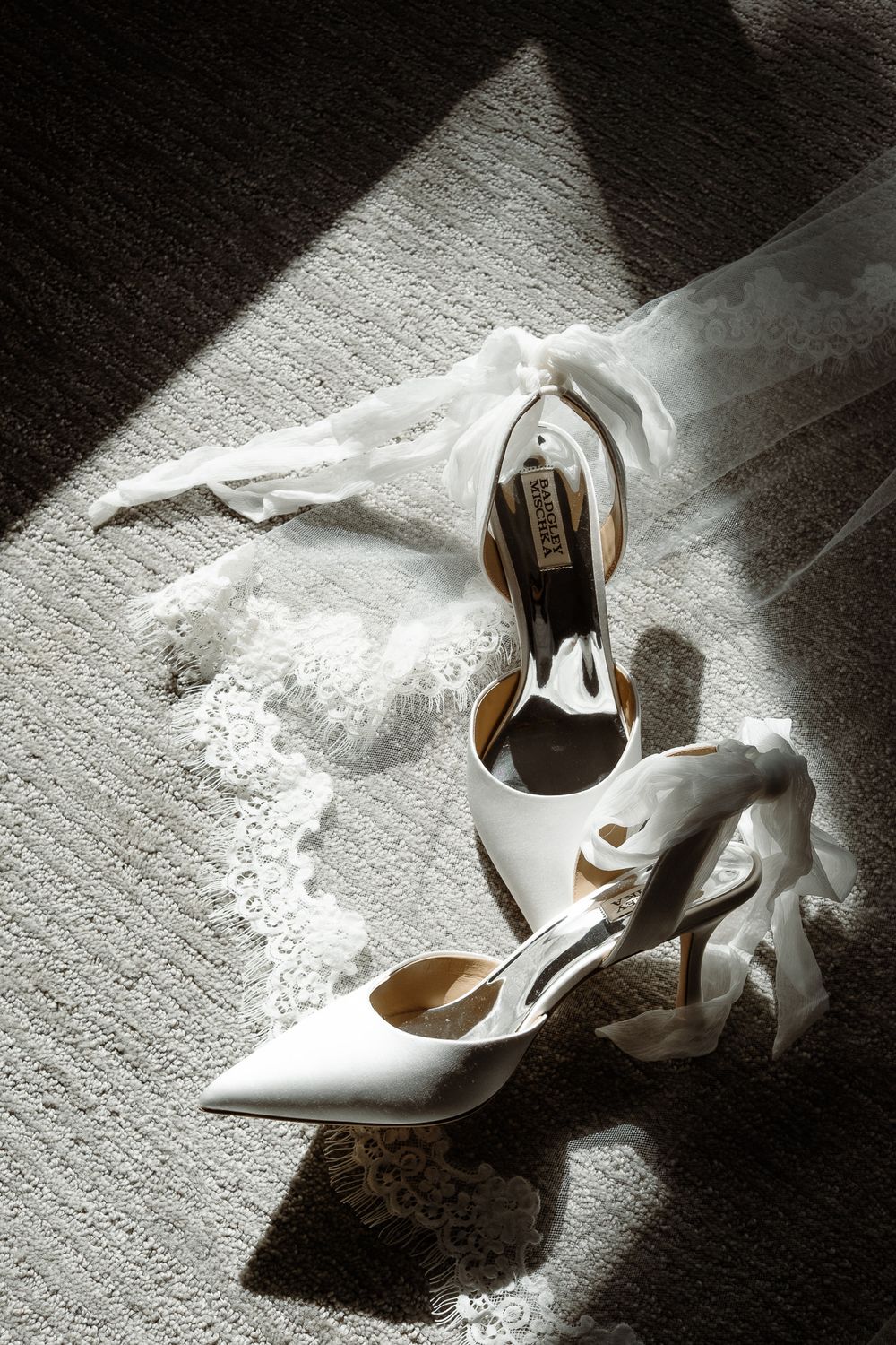 A dramatic still life photo series shows an elegant white high heel shoe in varying angles against dark shadows.