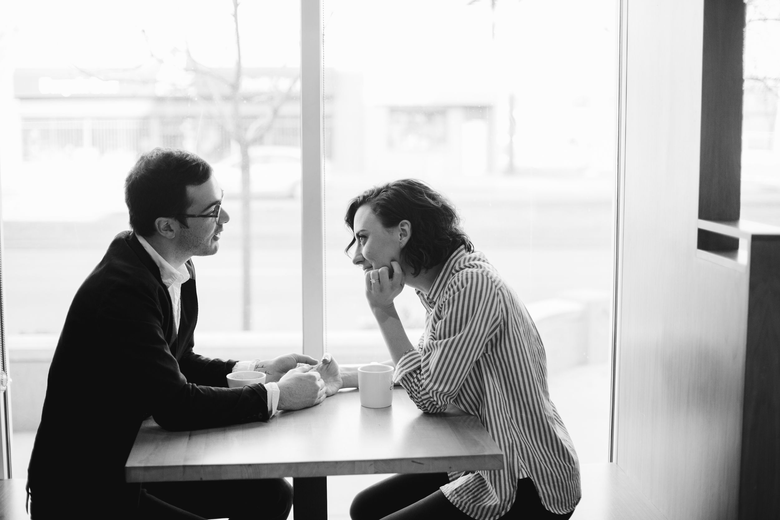 Two people having an intimate conversation at a cafe table.