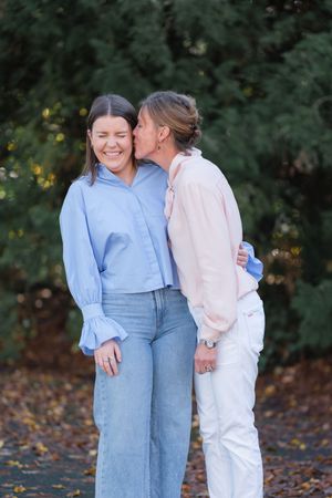 Candid moment between two people sharing laughter on an autumn day.