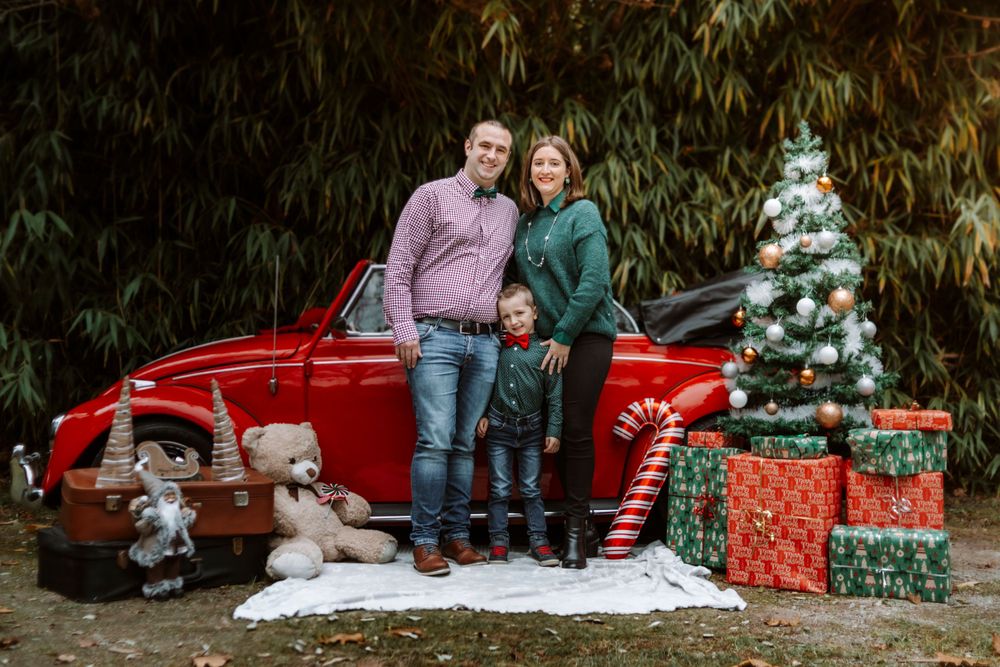 Mini-session photo de Noël 2024 avec une coccinelle VW rouge décorée pour les fêtes, créant une ambiance festive et chaleureuse.