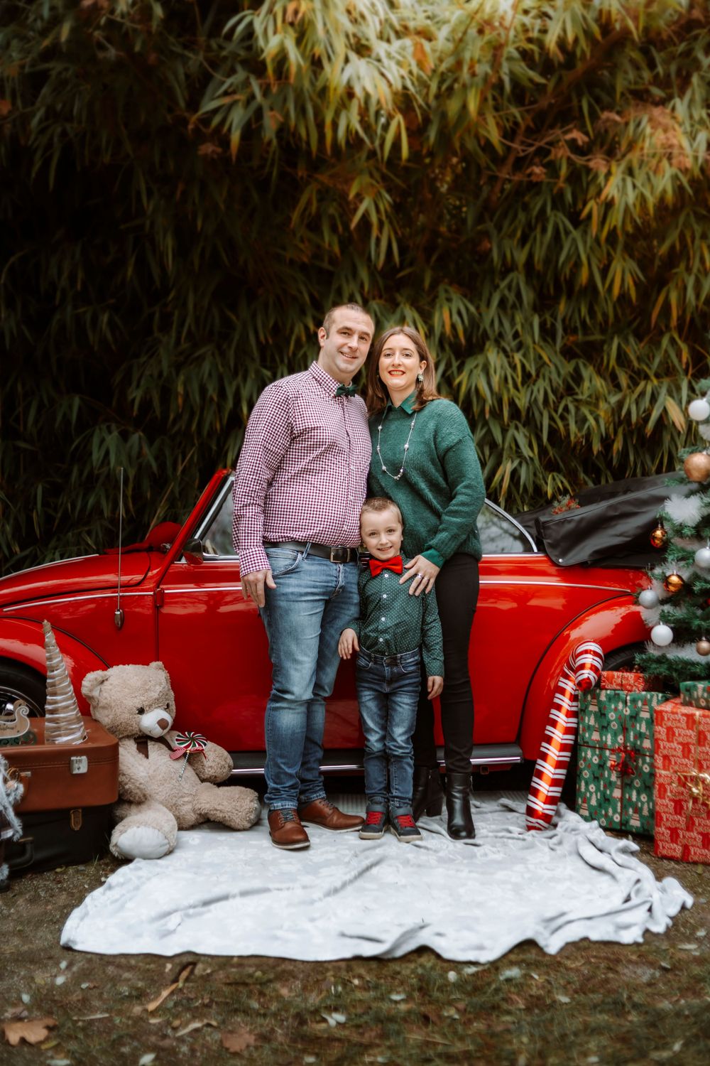 Mini-session photo de Noël 2024 avec une coccinelle VW rouge décorée pour les fêtes, créant une ambiance festive et chaleureuse.
