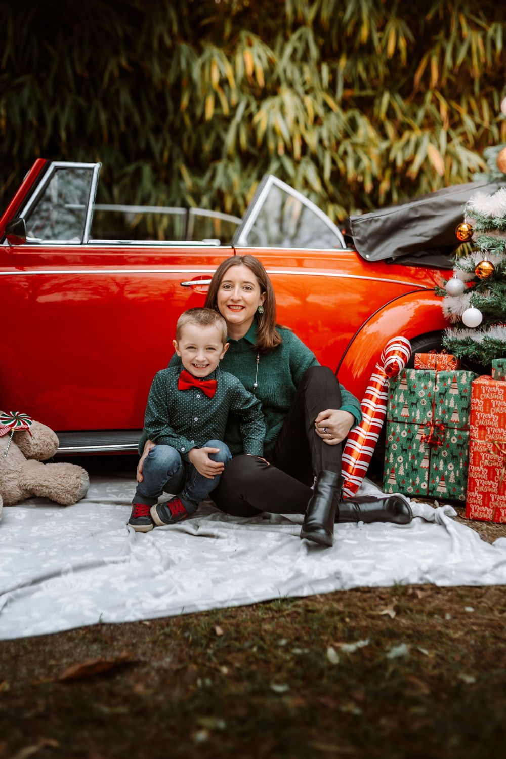 Mini-session photo de Noël 2024 avec une coccinelle VW rouge décorée pour les fêtes, créant une ambiance festive et chaleureuse.