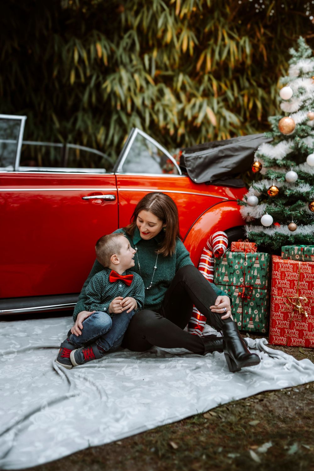 Mini-session photo de Noël 2024 avec une coccinelle VW rouge décorée pour les fêtes, créant une ambiance festive et chaleureuse.