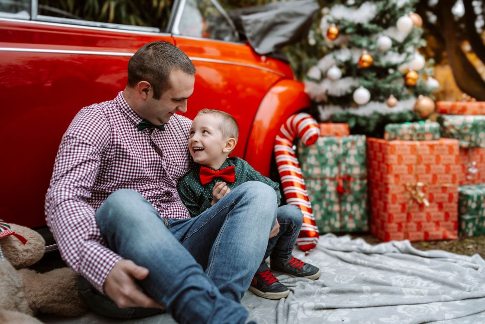 Mini-session photo de Noël 2024 avec une coccinelle VW rouge décorée pour les fêtes, créant une ambiance festive et chaleureuse.