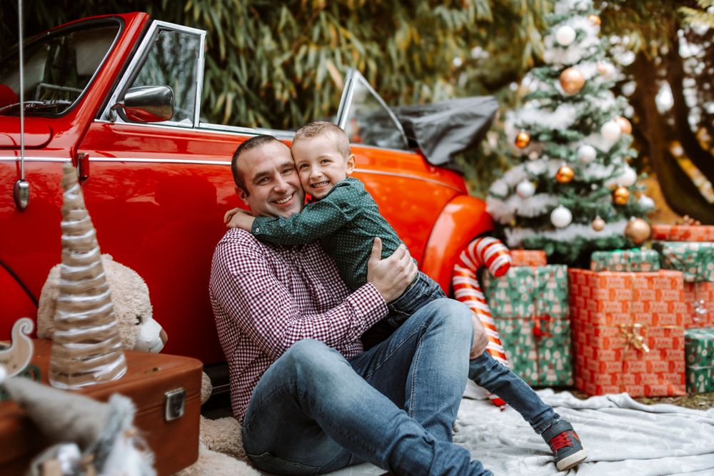 Mini-session photo de Noël 2024 avec une coccinelle VW rouge décorée pour les fêtes, créant une ambiance festive et chaleureuse.