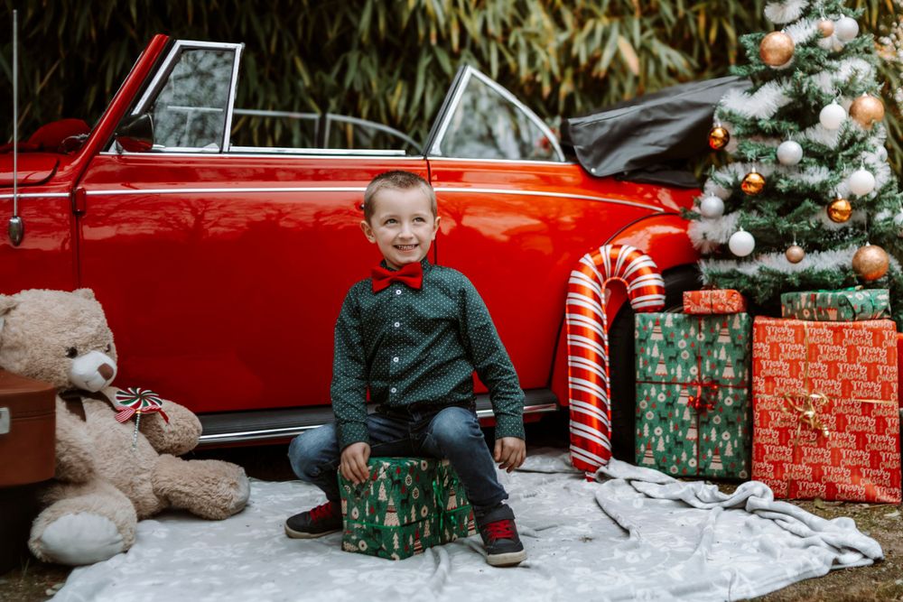 Mini-session photo de Noël 2024 avec une coccinelle VW rouge décorée pour les fêtes, créant une ambiance festive et chaleureuse.