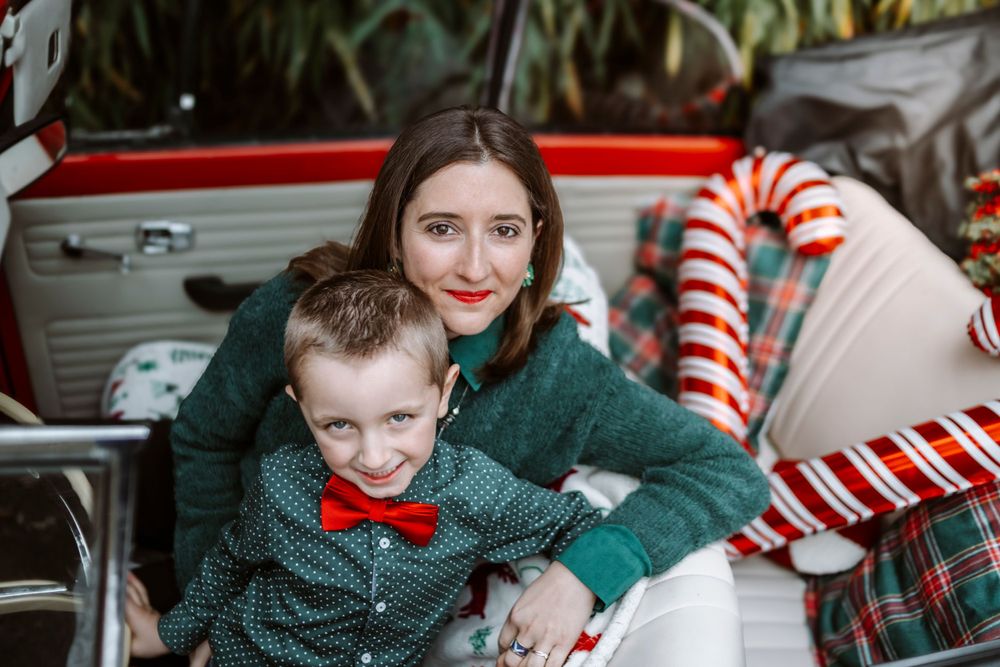 Mini-session photo de Noël 2024 avec une coccinelle VW rouge décorée pour les fêtes, créant une ambiance festive et chaleureuse.